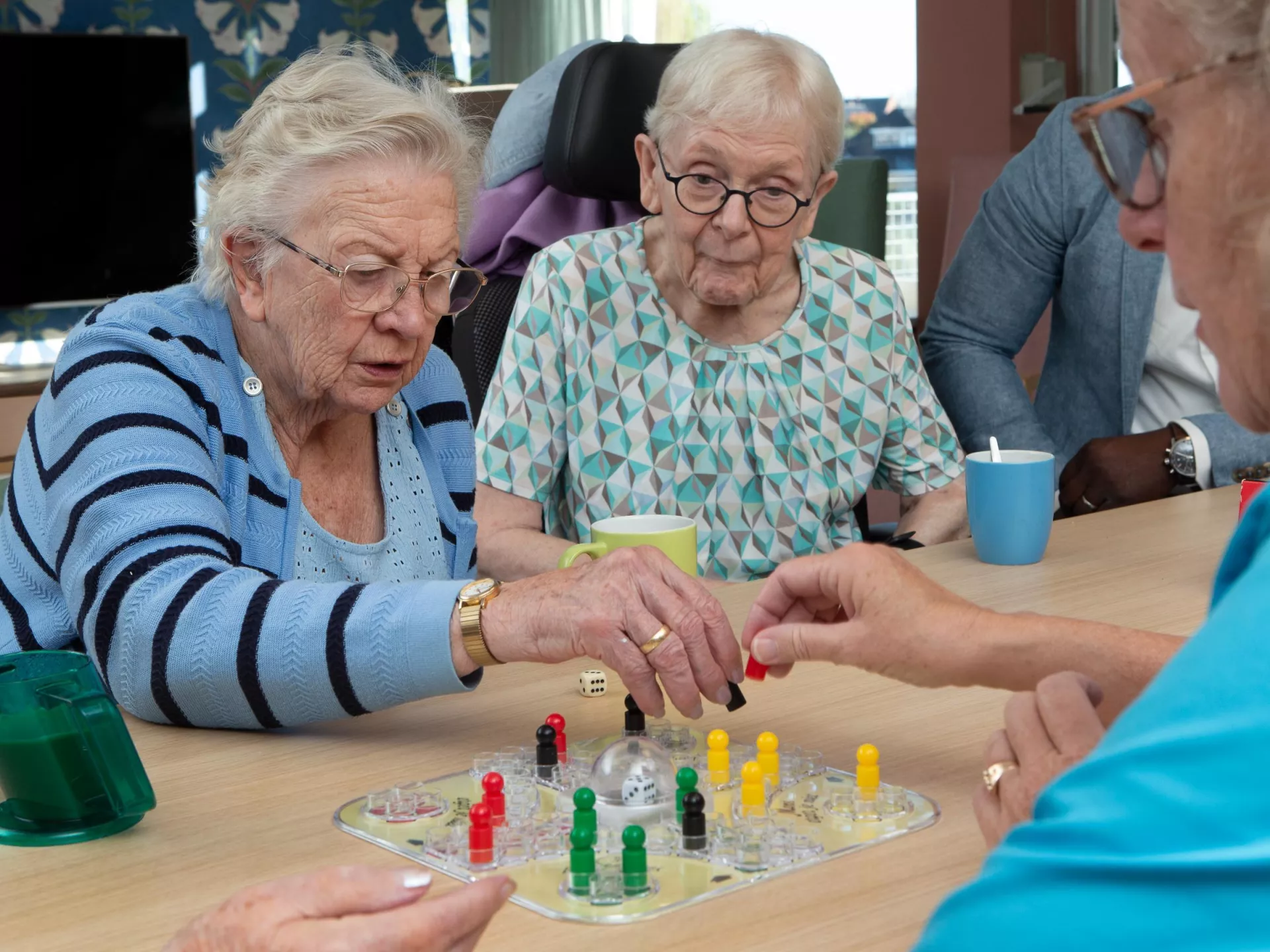 Ouderen spelen een bordspel samen aan tafel.