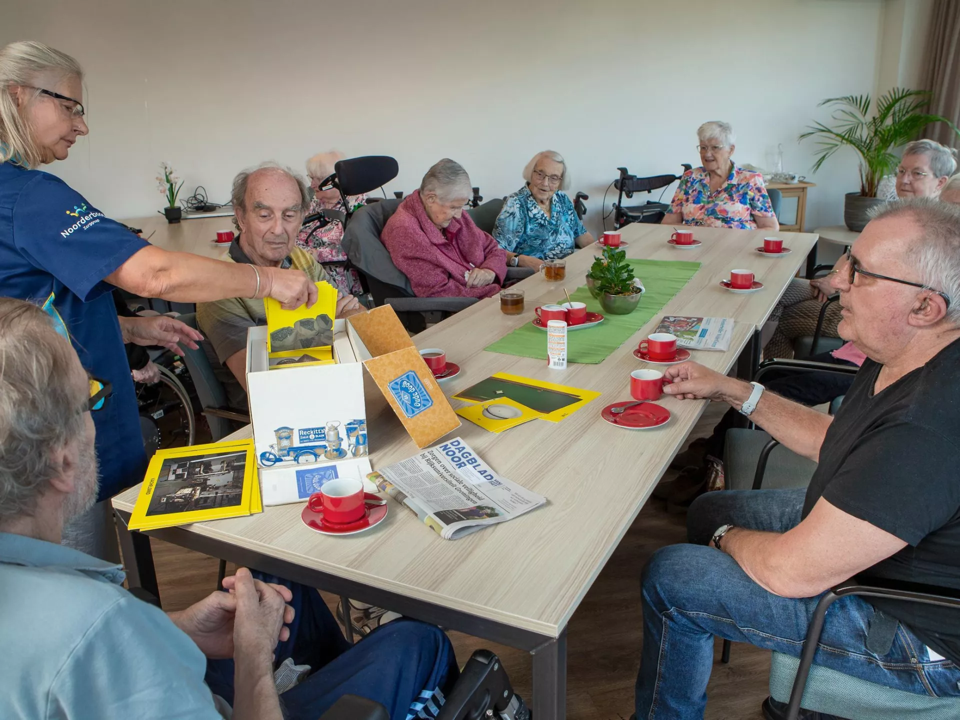 Groep ouderen aan tafel doen een spel.