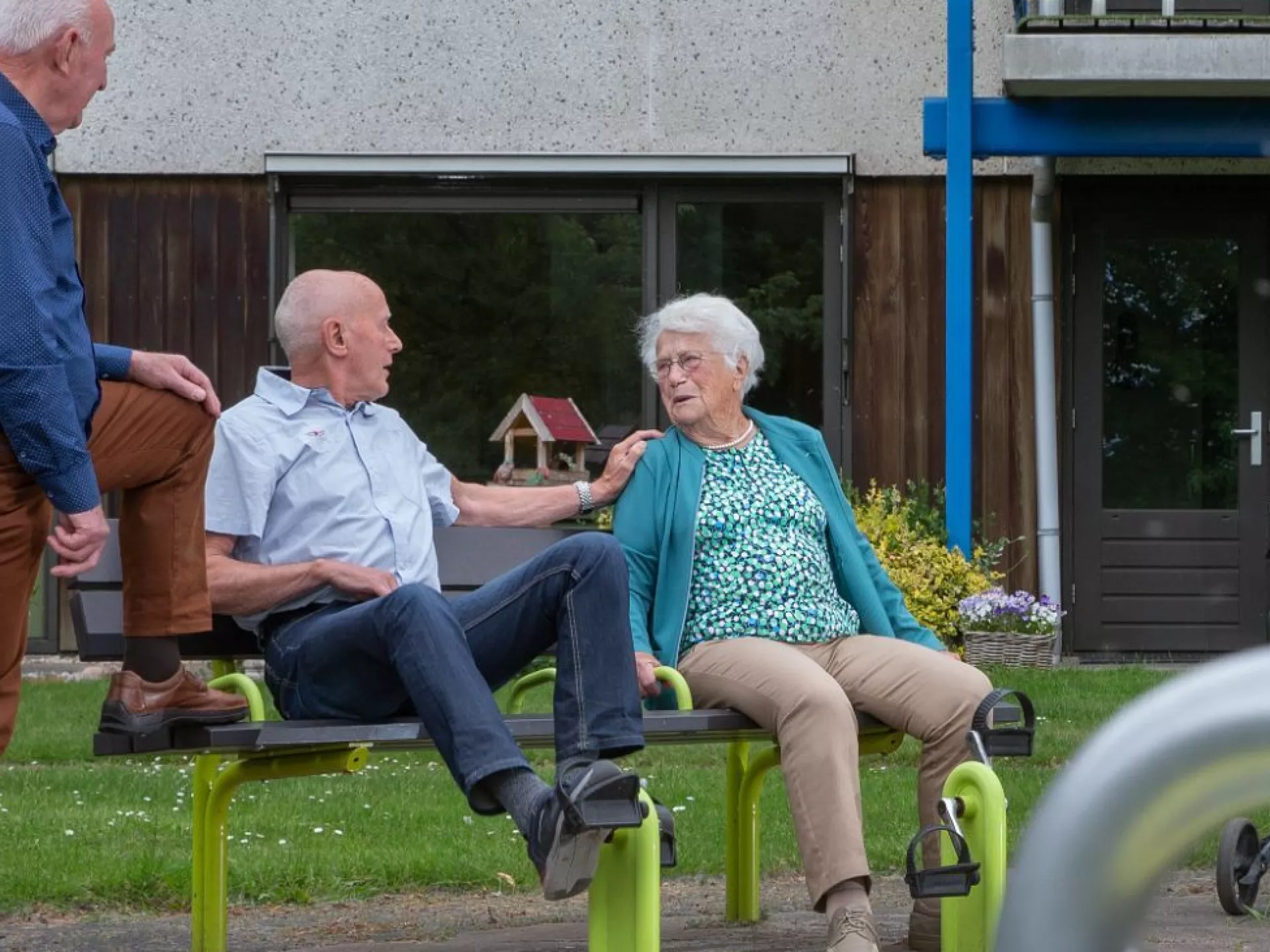 Senioren ontspannen op een bankje in een tuin.