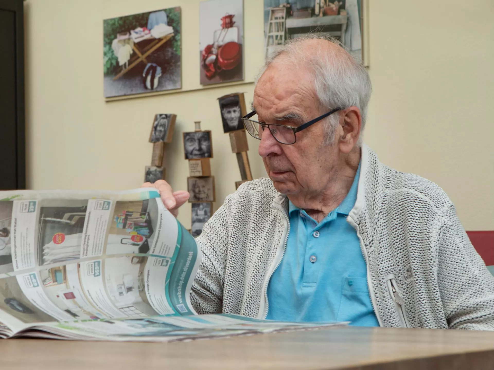 Een oudere man leest een krant in een sfeervolle woonkamer.