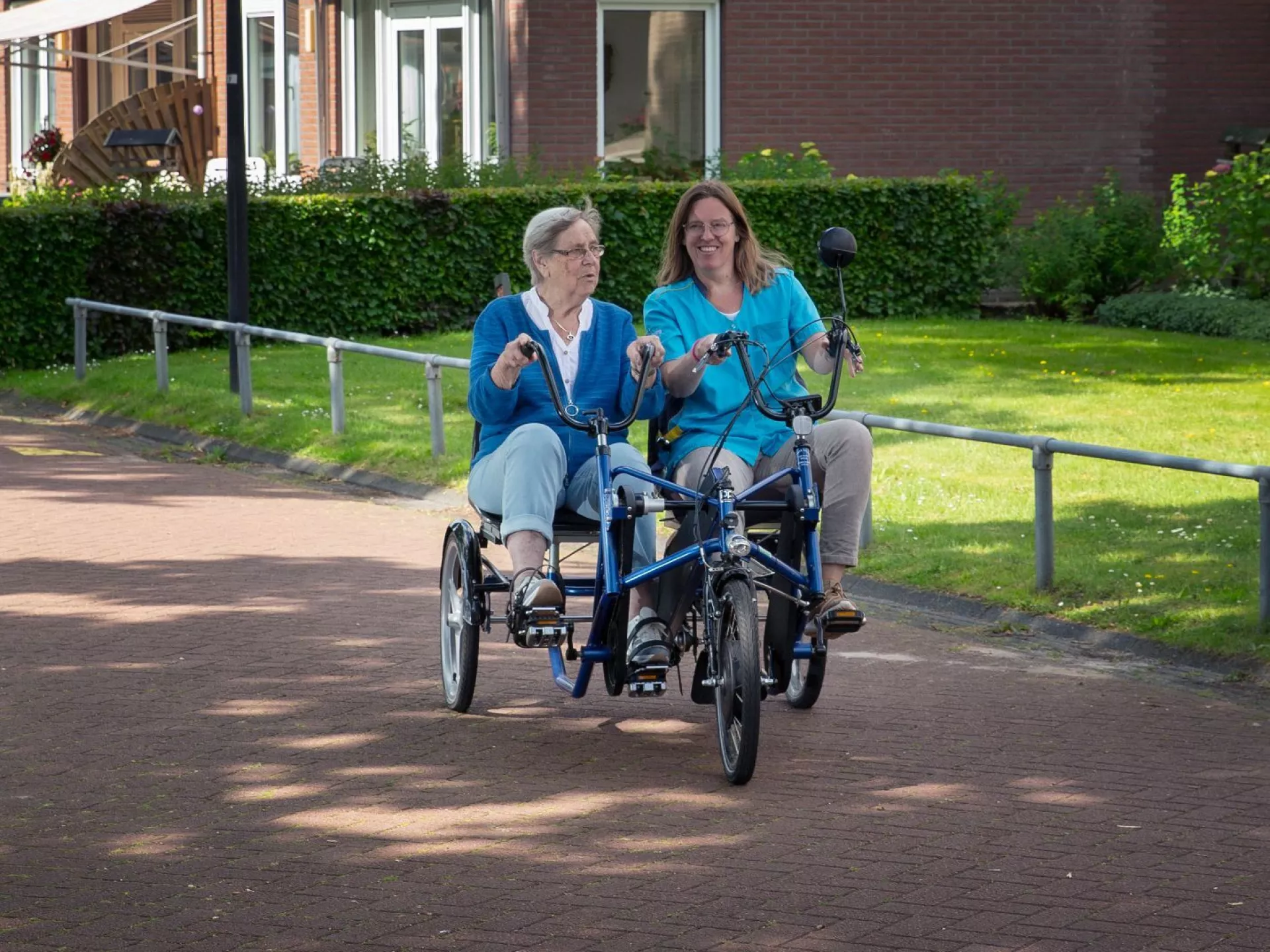 Twee mensen fietsen samen op een duofiets.