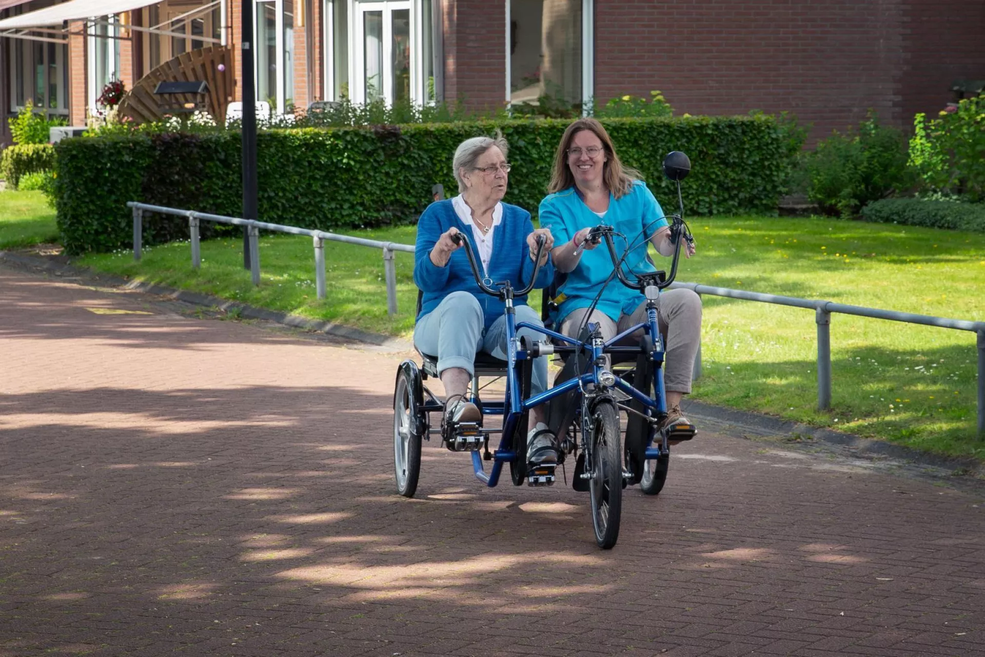 Twee mensen fietsen samen op een duofiets.